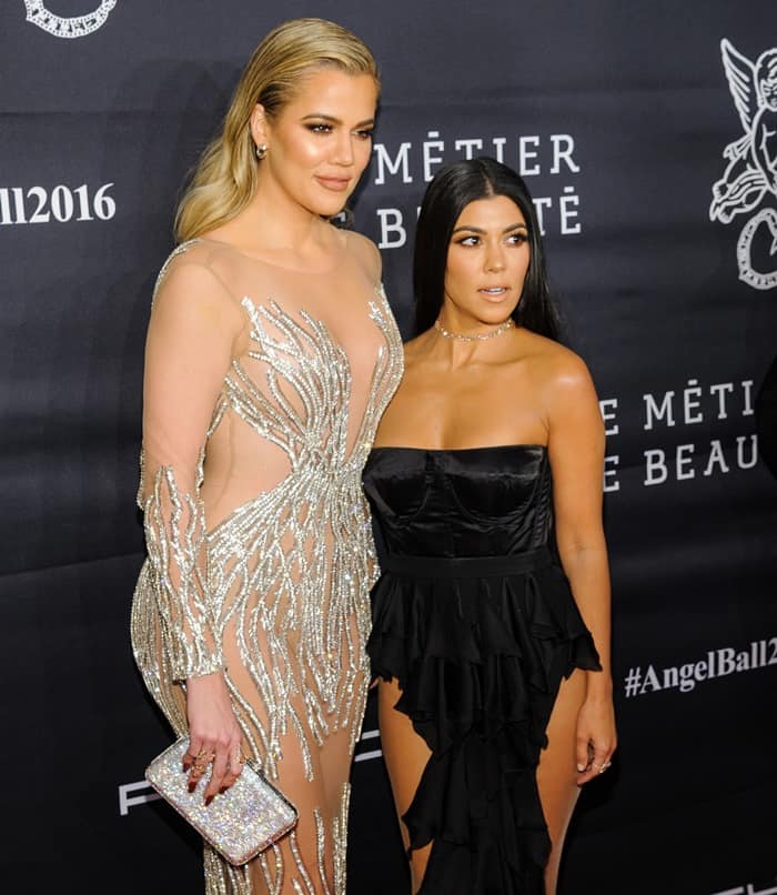 Khloe and Kourtney Kardashian flaunted their signature curves at the 2016 Angel Ball, with Khloe towering over her sister in a sheer, beaded gown while Kourtney opted for a strapless black ruffled dress