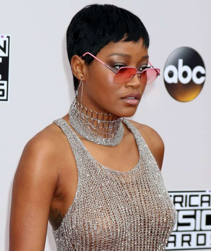 Keke Palmer pairing her metallic see-through Natalia Fedner outfit with a sleek pixie cut and edgy pink-tinted sunglasses