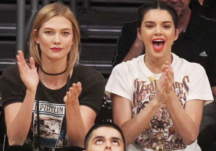 An ecstatic Kendall Jenner cheers alongside a less enthusiastic Karlie Kloss