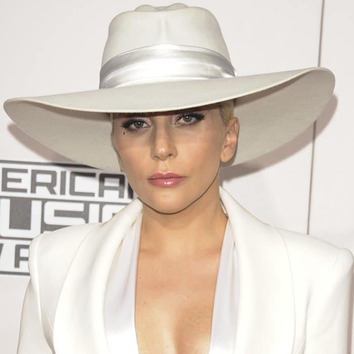 Lady Gaga exudes elegance at the 2016 American Music Awards in a chic white Brandon Maxwell tuxedo, complete with a matching wide-brimmed Gladys Tamez hat