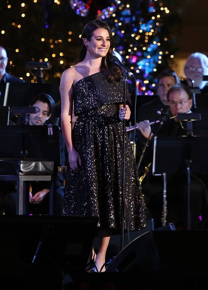 Lea Michele glistened in a gold-patterned black dress as she performed a few Christmas songs