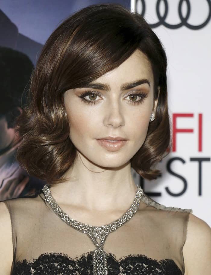Lily Collins' lustrous brunette hair was styled in a side-parted bob, with vintage curls delicately framing her face