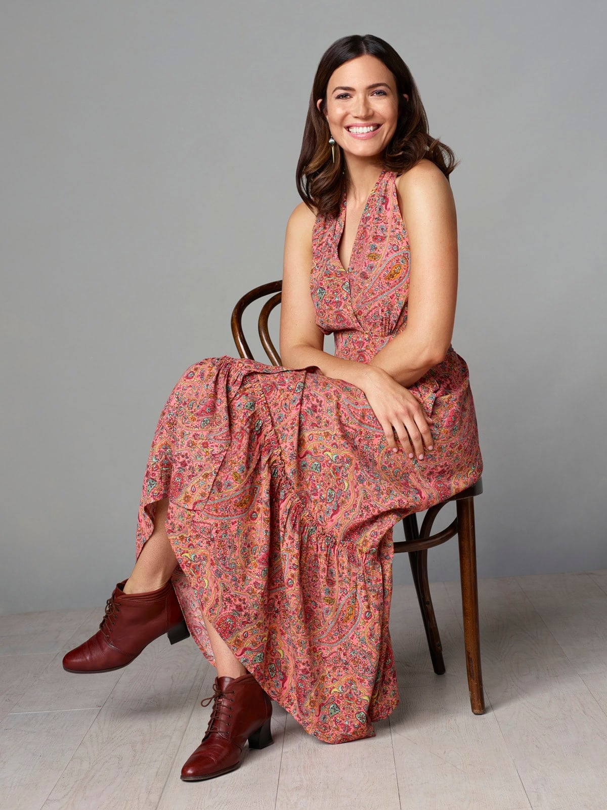 Mandy Moore channels her This Is Us character Rebecca Pearson’s ’70s spirit in a paisley maxi dress paired with lace-up leather ankle boots in this Season 4 promotional portrait