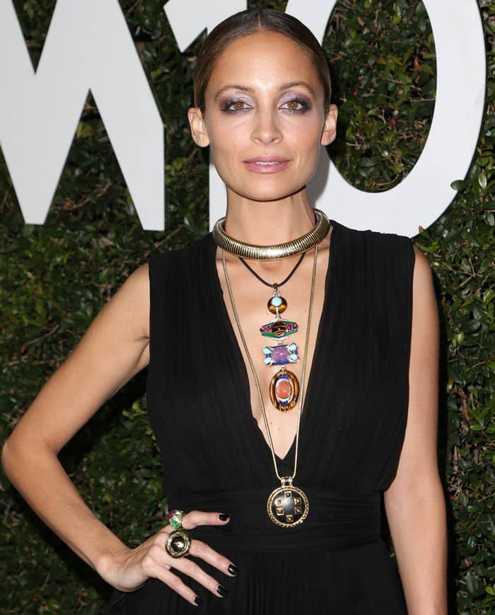 Nicole Richie wears her hair in a sleek, center-parted low bun, complementing her makeup with a soft smoky eye and nude lips
