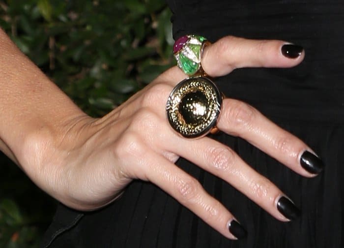 Nicole Richie complements her look with bold statement rings, featuring intricate designs and vibrant gemstones, including emerald green and deep purple