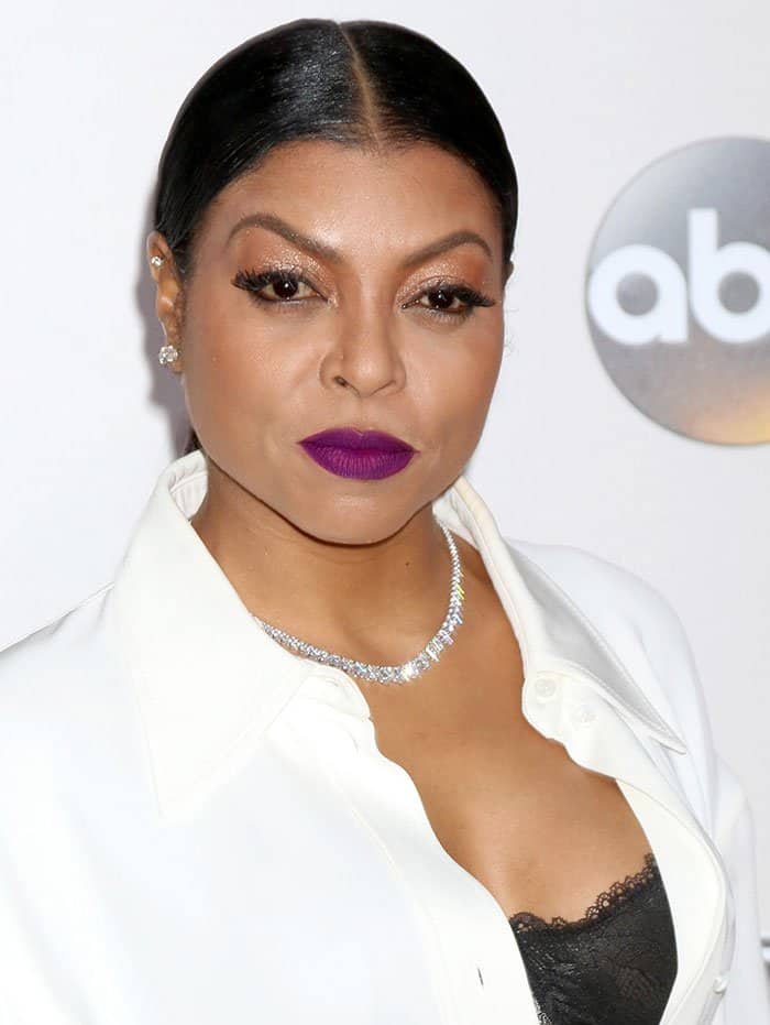 Taraji P. Henson complements her bold magenta lips with a sleek, center-parted ponytail and a sparkling Hearts on Fire diamond necklace