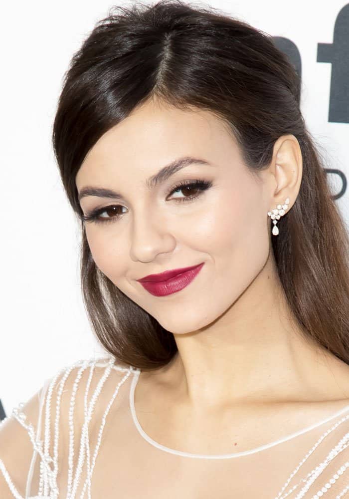 Victoria Justice exudes elegance in a sheer, beaded gown paired with striking Harry Winston jewelry, showcasing her timeless beauty at the amfAR Inspiration Gala