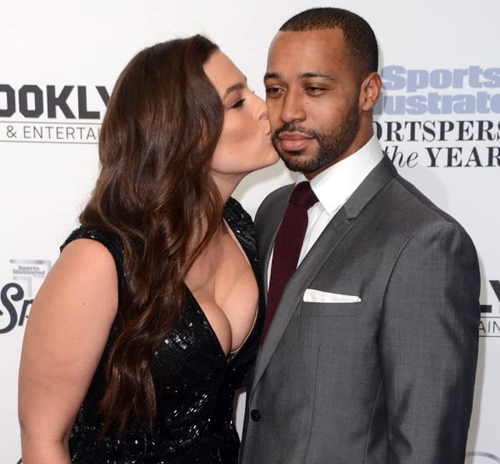 Ashley Graham shares a sweet moment, giving her husband, Justin Ervin, a kiss on the cheek while they pose together at the 2016 Sports Illustrated Sportsperson of the Year Ceremony