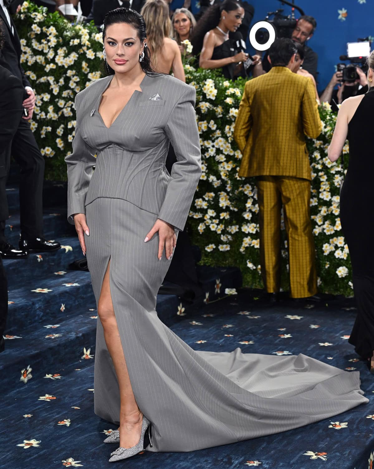 Ashley Graham exuded power and polish in a bespoke pinstripe wool gown by BOSS with structured shoulders and a boned bustier, completing the look with glittering Roger Vivier pumps at the 2025 Met Gala
