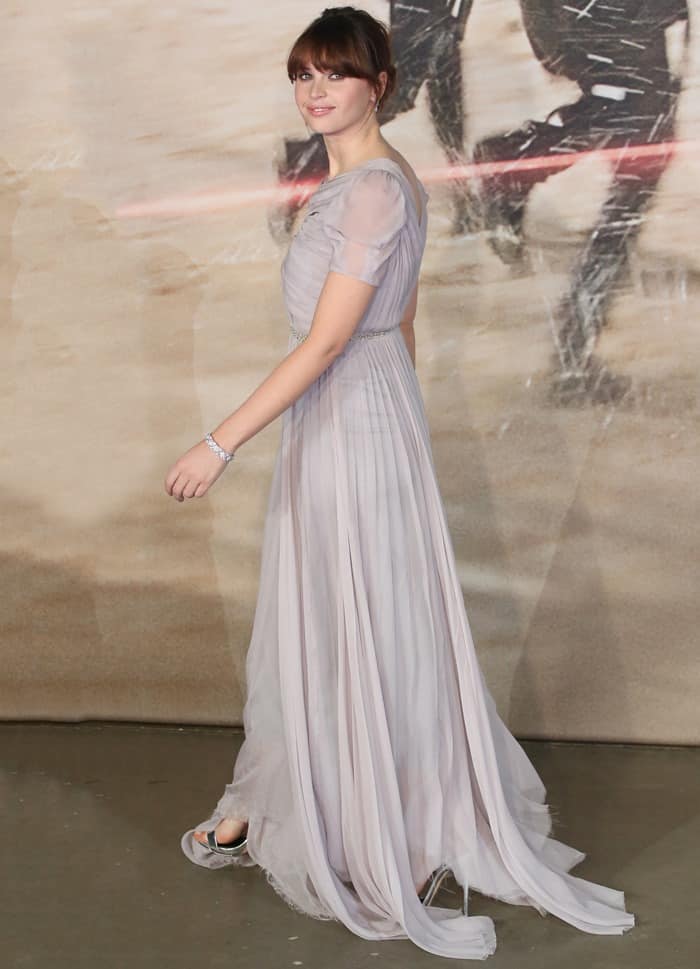 Felicity Jones gracefully posed in her pale lavender Giambattista Valli gown, accessorized with a delicate silver bracelet and metallic sandals that complemented the gown's soft, flowing design