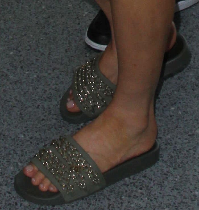 Fergie shows off her chic olive green Chanel slides adorned with gold chain details, complemented by a natural pedicure