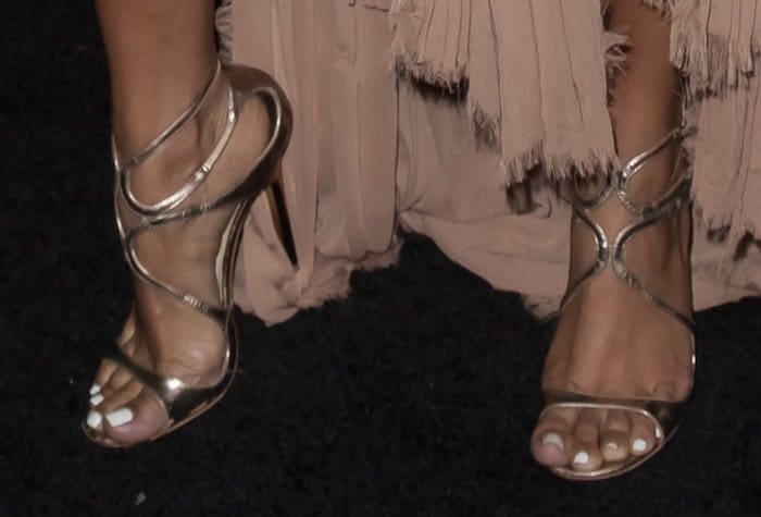 Karrueche Tran shows off her feet in wavy-strap sandals in bronze