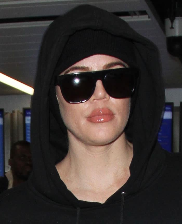 Khloe Kardashian wears Saint Laurent Sl1 sunglasses and a Tackma the Calm Hood hoodie