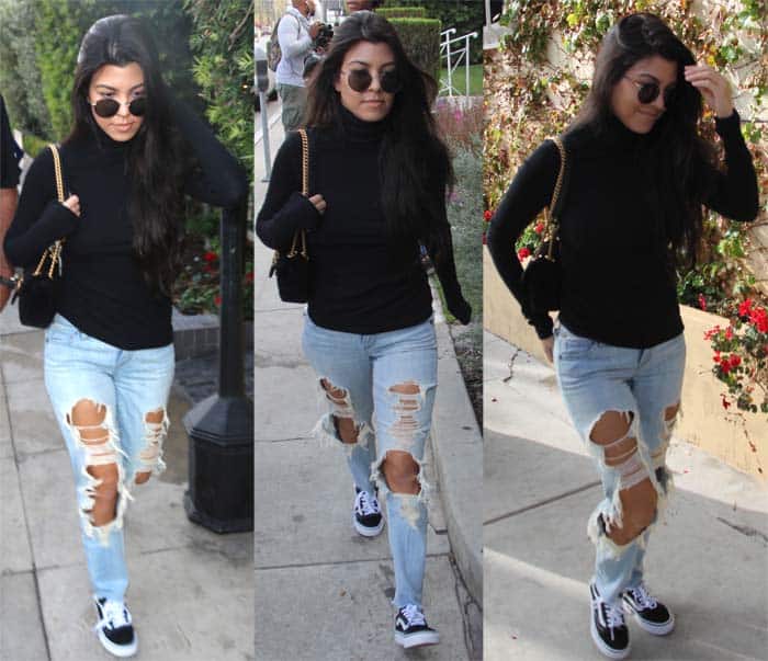 Kourtney Kardashian in distressed jeans and a black turtleneck paired with Vans 'Old Skool' sneakers