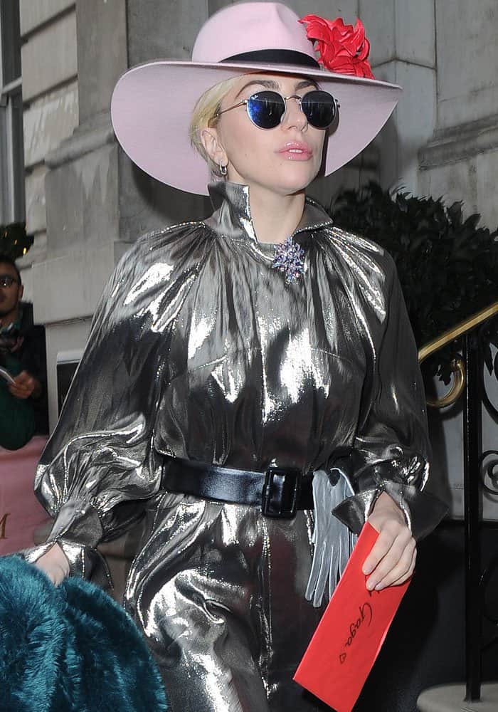 Lady Gaga steps out in a bold metallic Ellery "Witch Doctor" mini dress paired with a statement pale pink hat adorned with a red flower