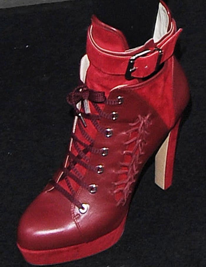 A close-up of Lady Gaga's striking red Rebecca Björnsdotter "Tove" boots, featuring lace-up detailing and a chunky heel