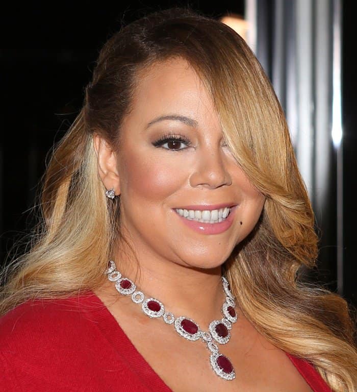Mariah Carey's soft pink lips perfectly complement her radiant smile, while her signature mole under her lips adds a touch of natural charm