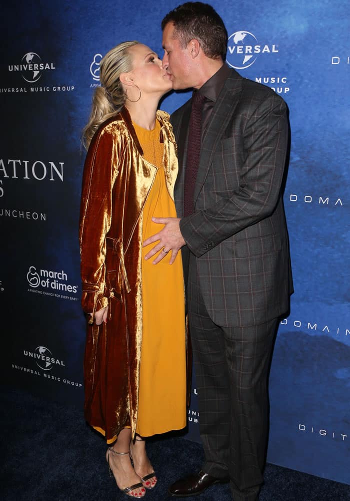 Molly Sims shares a sweet moment with her husband, Scott Stuber, glowing in a golden autumn-hued maternity dress and velvet coat at the March of Dimes 'Celebration of Babies' event