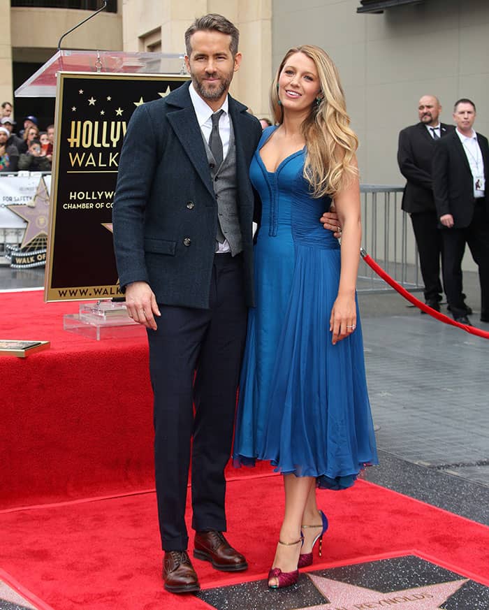 Ryan Reynolds looked dapper in a dark tailored coat over a gray vest and tie, while Blake Lively stunned in a blue Versace midi dress paired with elegant accessories