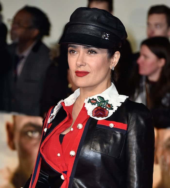 Salma Hayek’s Gucci leather jacket featured bold red grosgrain trim, pearl buttons, and an eye-catching embroidered rose motif on the crisp white collar