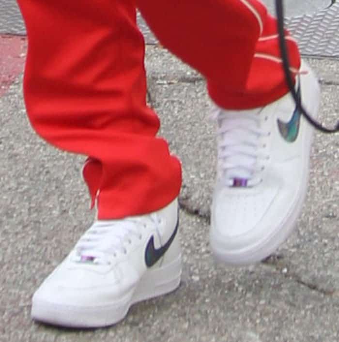 Bella Hadid adds a unique touch to her outfit with Nike Air Force 1 High Lv8 sneakers, featuring an iridescent Swoosh that catches the light with every step