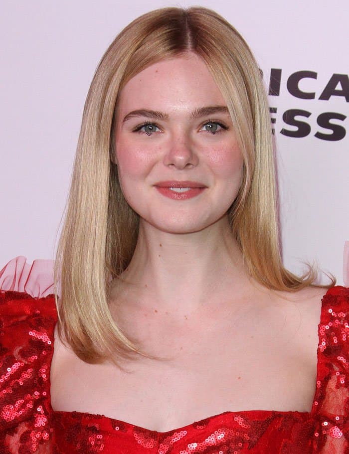 Elle Fanning kept her look effortlessly elegant with soft, straight blonde hair and natural makeup featuring a rosy blush, subtle eyeliner, and a glossy nude lip