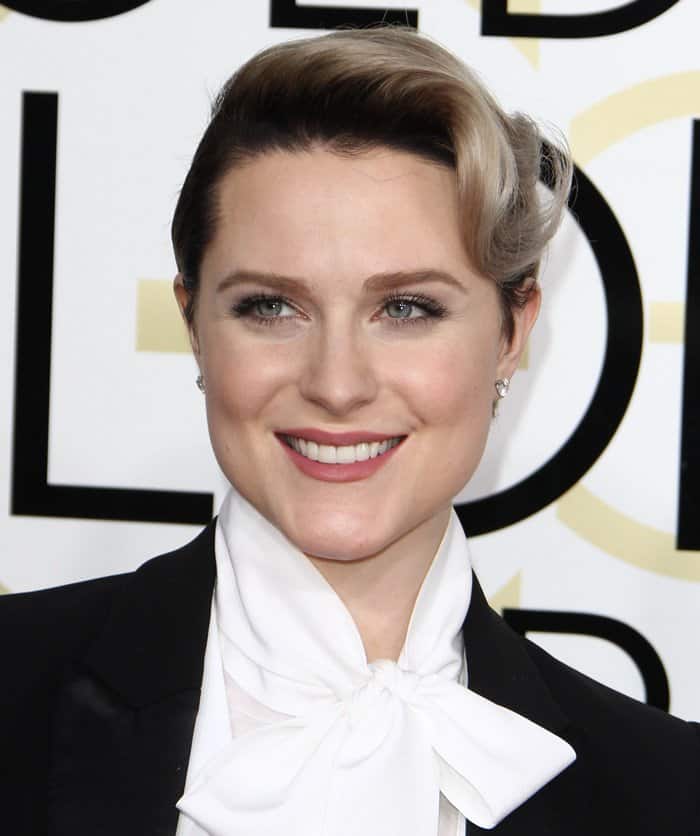 Evan Rachel Wood styled her hair in a sleek, retro wave, complementing her classic tuxedo look, while her makeup featured soft, neutral tones with a natural pink lip and lightly defined eyes