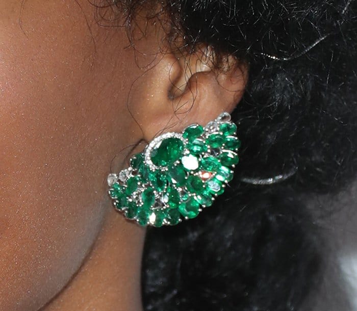The intricate design of Janelle Monáe's emerald earrings features a fan-like arrangement of vibrant green gemstones accented with sparkling diamonds