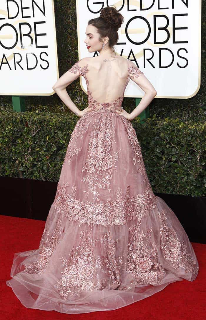 Lily Collins exudes elegance in a breathtaking Zuhair Murad gown with intricate lace detailing and a dramatic open back at the 74th Golden Globe Awards