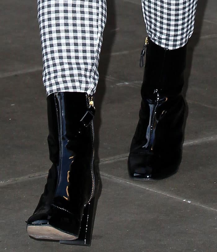 Maisie Williams in glossy patent boots