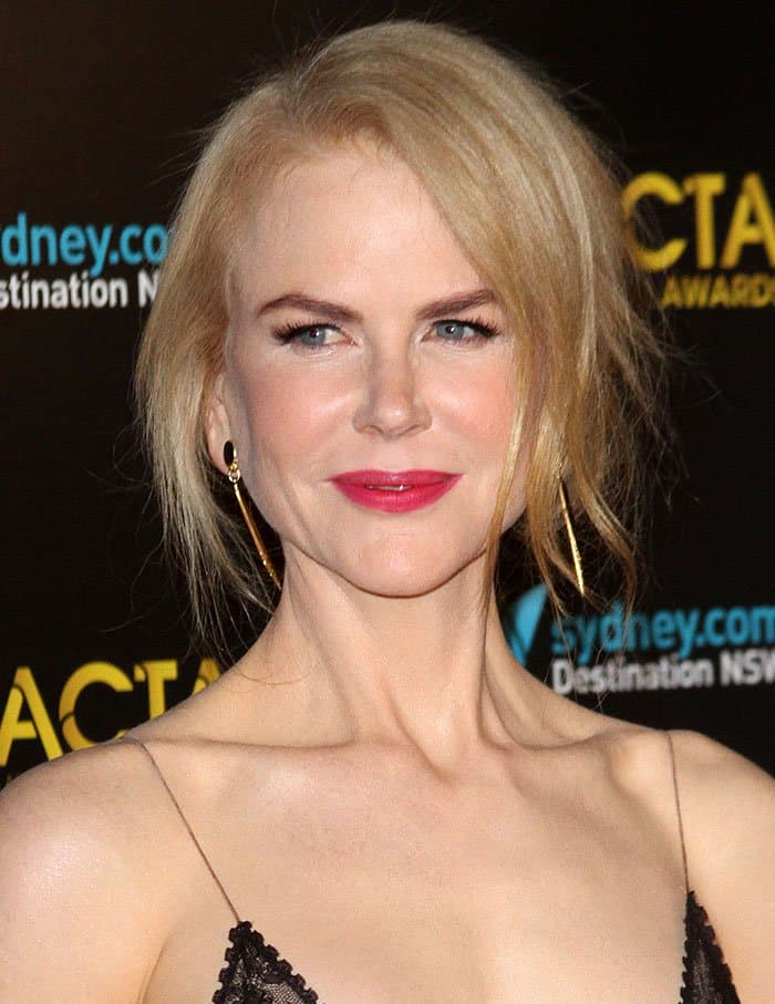 Nicole Kidman radiates elegance with bold fuchsia lipstick, soft blush, and gold drop earrings