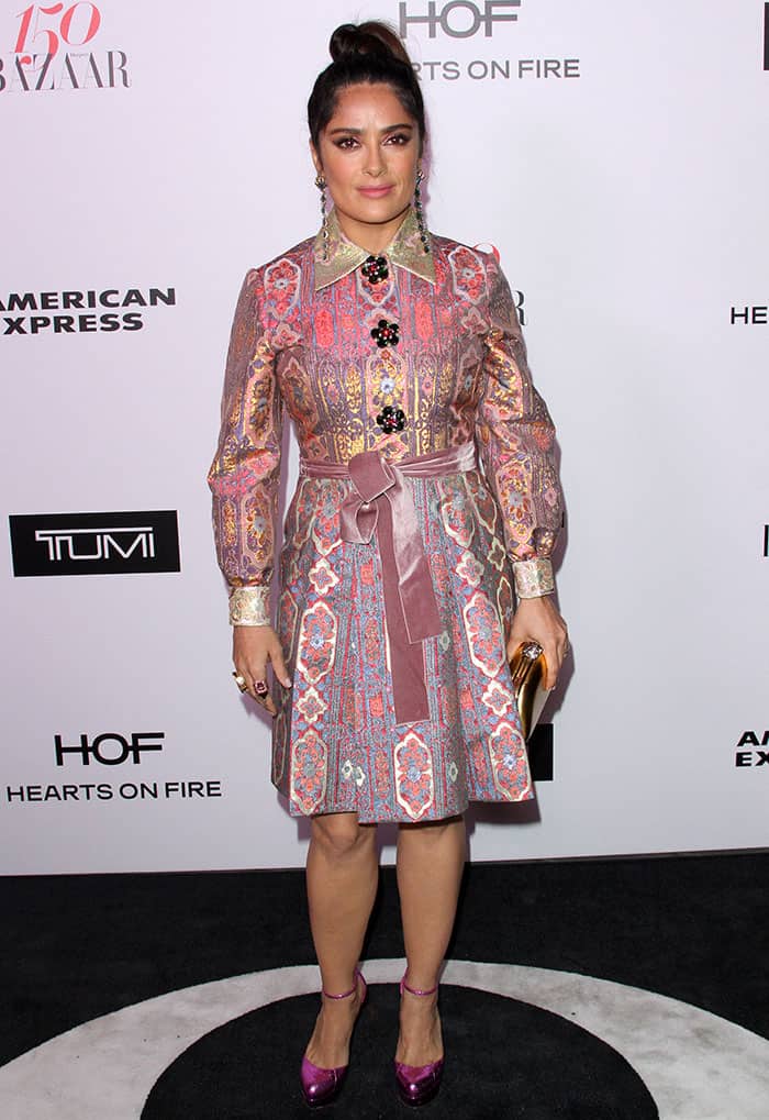Salma Hayek dazzles in a vibrant Gucci jacquard dress paired with metallic pink platform pumps, accessorized with bold jewelry and a chic updo