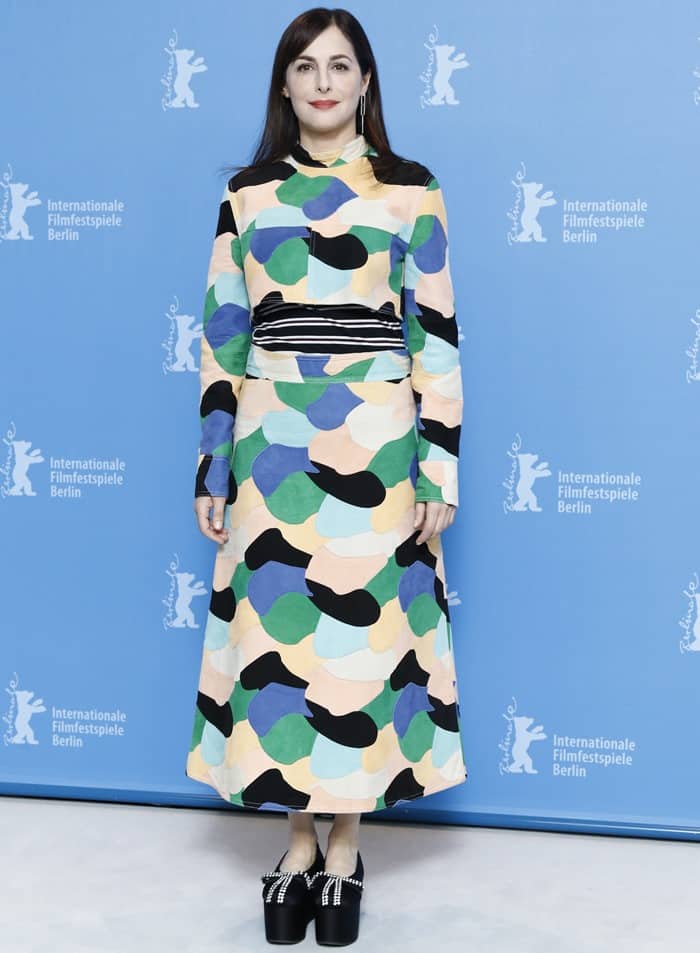 Amira Casar showcases a vibrant Marni Resort 2017 dress with abstract patterns, paired with quilted platform wedges, a look that can be replicated by mixing bold, colorful prints with statement shoes for a modern retro vibe