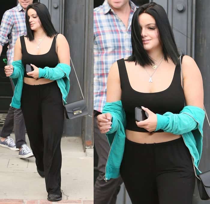 Ariel Winter steps out in a chic, casual look, pairing a belly-baring black crop top with relaxed black pants, an aqua jacket, and layered necklaces