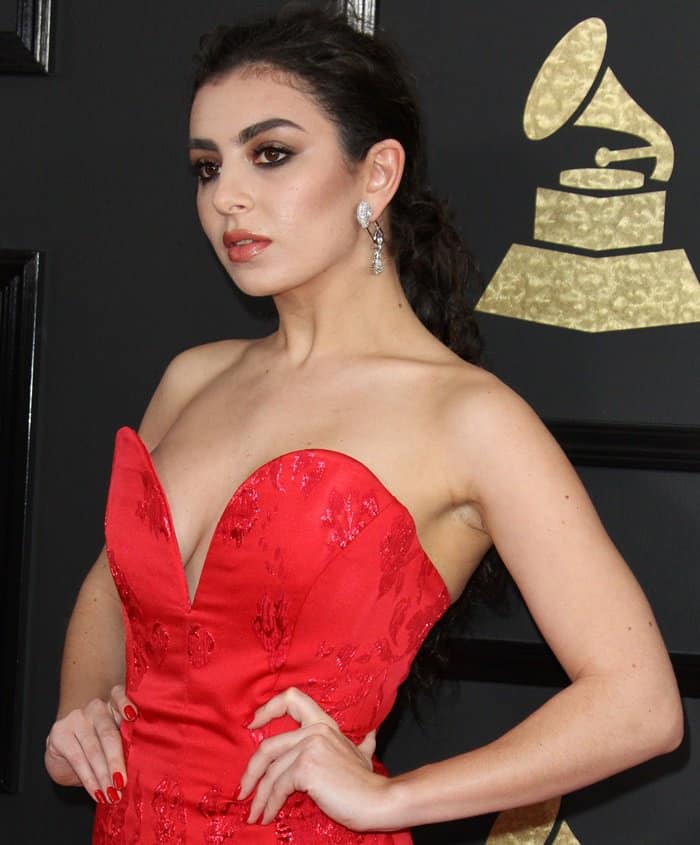 Charli XCX’s Vivienne Westwood gown dazzles with its structured sweetheart neckline, intricate floral embroidery, and vibrant red hue