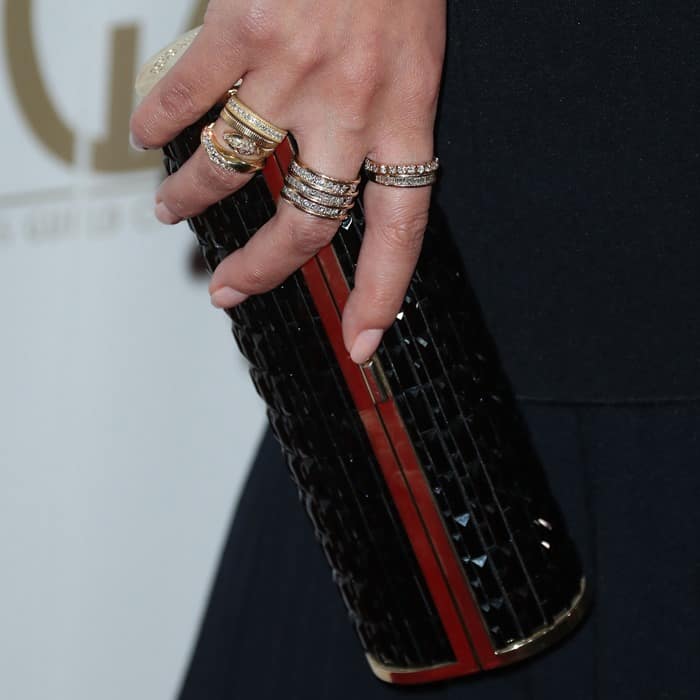 Chrissy Teigen added a touch of glamour with stacked diamond rings, a glossy black manicure, and a sparkling mosaic clutch to complete her red carpet look