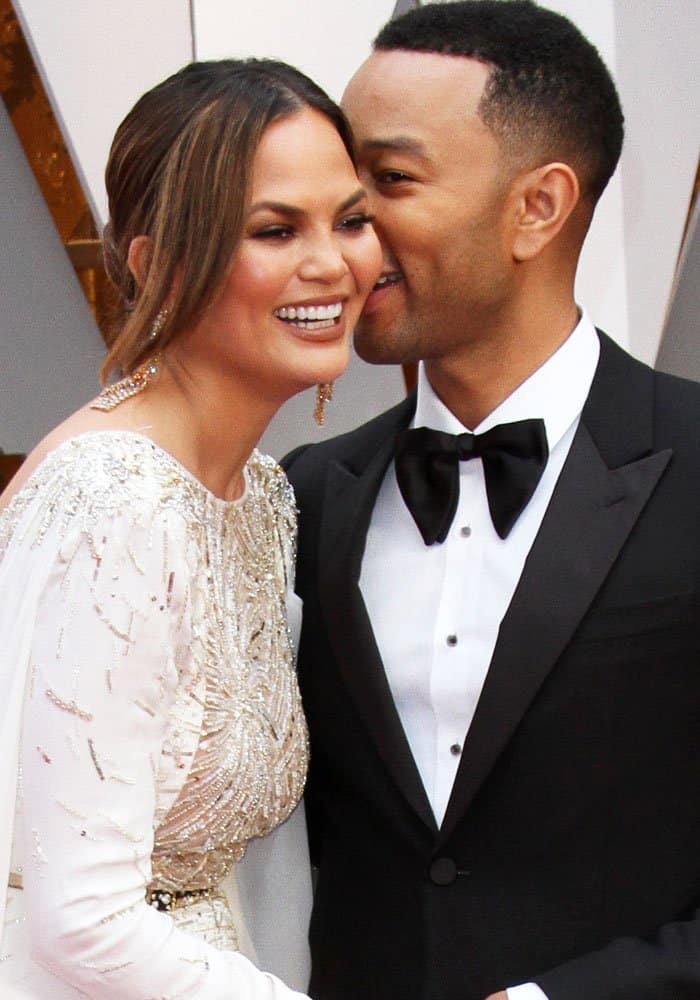 Chrissy's husband John whispers sweet nothings into her ear