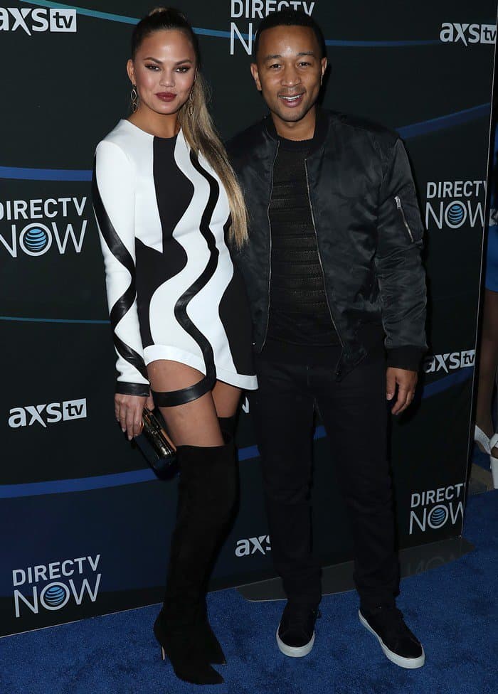 Chrissy Teigen and John Legend made a stylish duo, with Chrissy in a bold black-and-white Alon Livne dress and thigh-high boots, and John in a sleek all-black ensemble