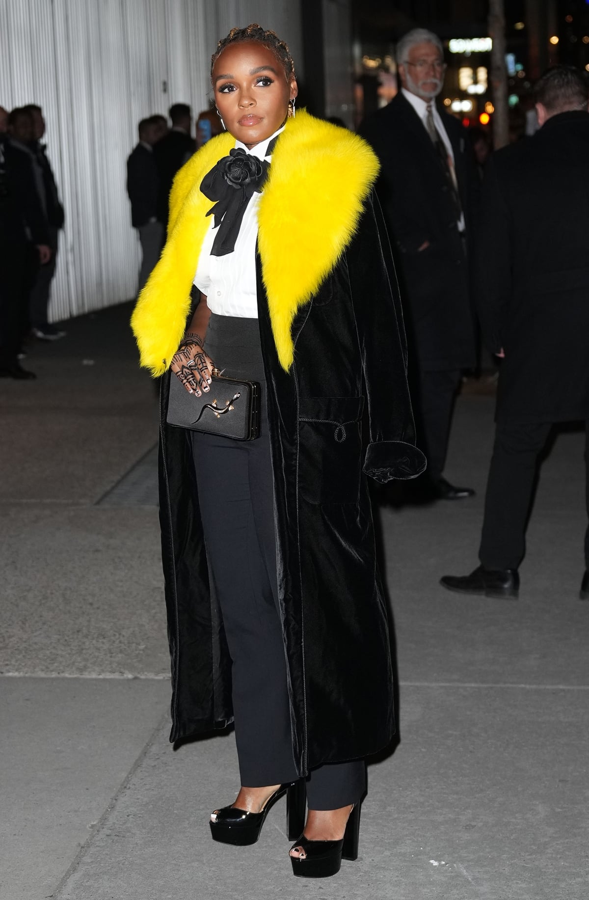 Janelle Monáe wears a yellow faux fur coat over a suit at the Ralph Lauren AW22 show