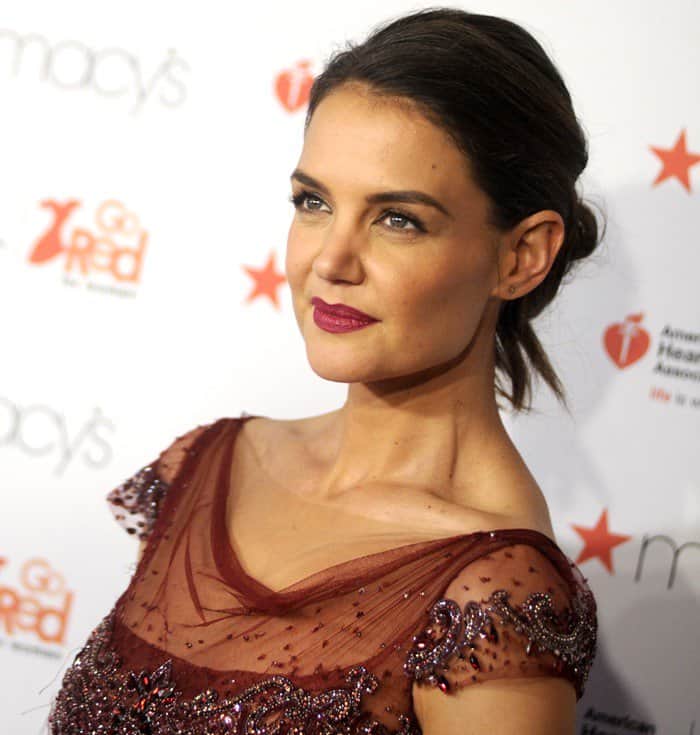 Katie Holmes styled her hair in a sleek, low bun, allowing the intricate details of her beaded maroon gown to shine