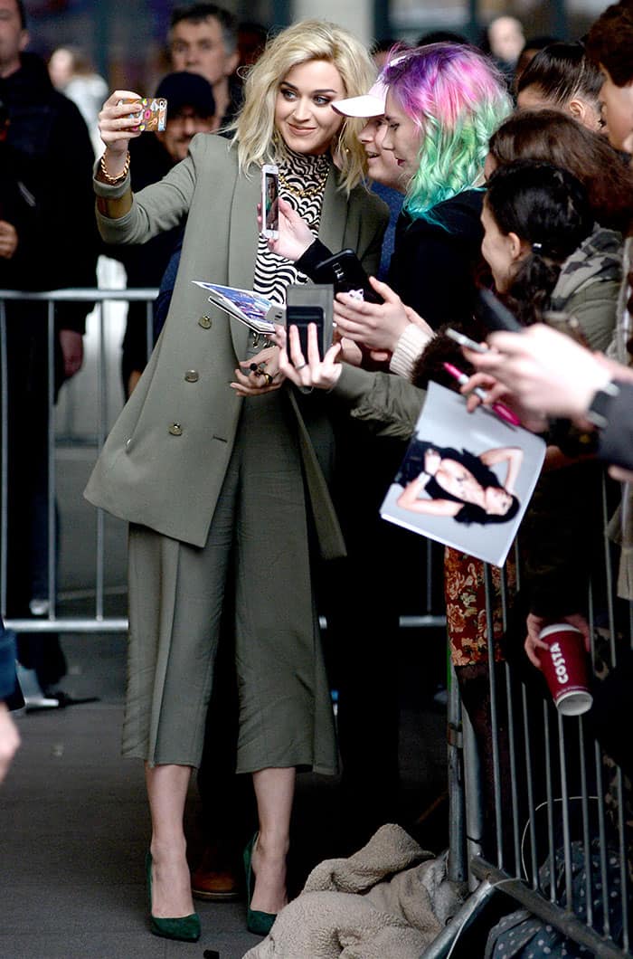 Katy Perry wearing an Elisabetta Franchi blazer and culottes, a Vanessa Seward turtleneck top, and green suede pumps