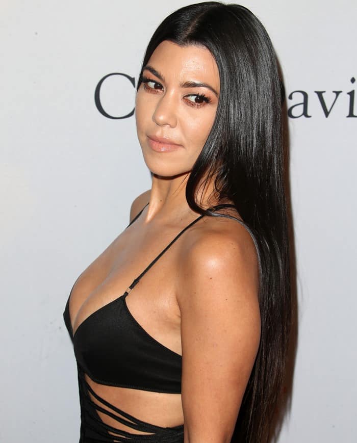 Kourtney Kardashian flaunts her sleek, pin-straight hairstyle with a deep center part