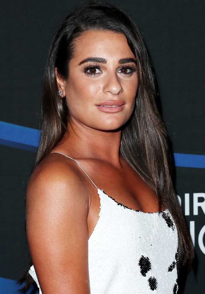 Lea Michele stuns with sleek straight hair, soft nude makeup, and a sequined white slip dress adorned with black accents
