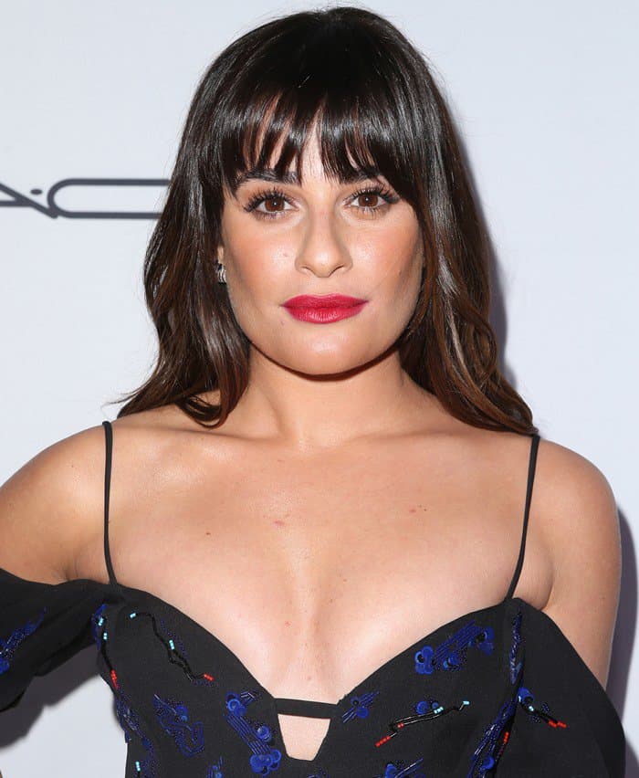 Lea Michele's sleek, shoulder-length hairstyle features soft waves and eye-grazing bangs, perfectly complementing the delicate spaghetti straps and intricate embroidery of her J. Mendel dress