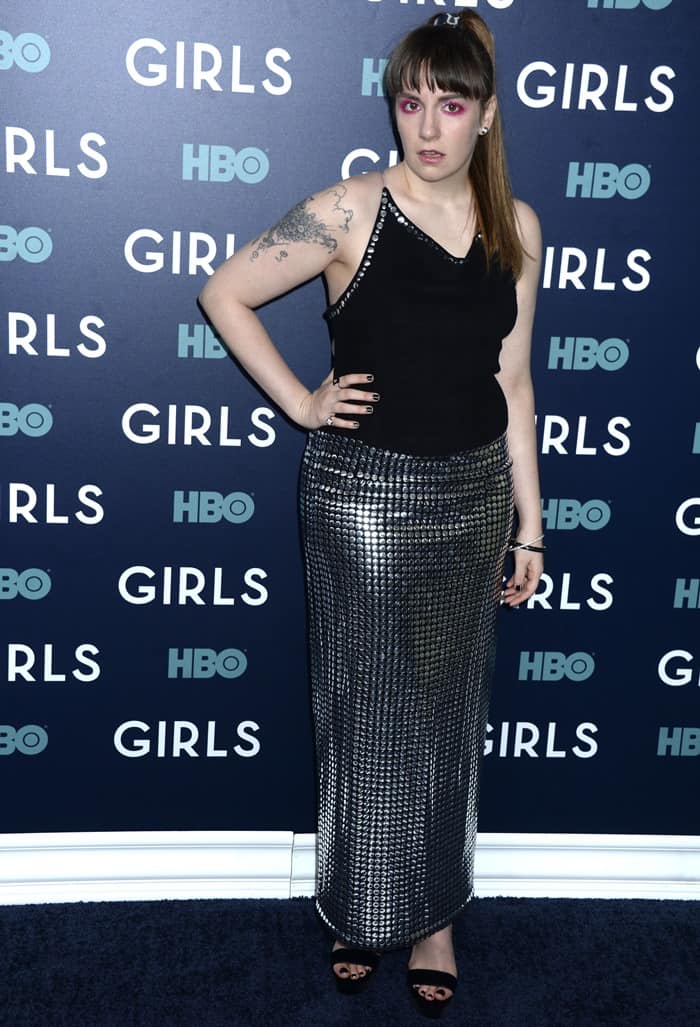 Lena Dunham channels retro glam with a studded silver skirt, sleek black tank, and bold pink eye makeup, paired effortlessly with black Jimmy Choo sandals at the 'Girls' premiere