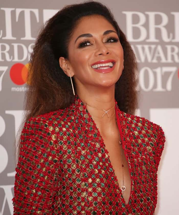 Nicole Scherzinger radiates joy with her dazzling smile, complemented by her glowing makeup featuring bold lashes, a soft pink lip, and perfectly contoured cheeks