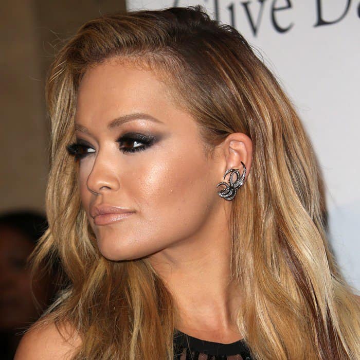 Rita Ora rocked a bold smoky eye, tousled waves, and edgy statement earrings, exuding a glamorous and fierce vibe