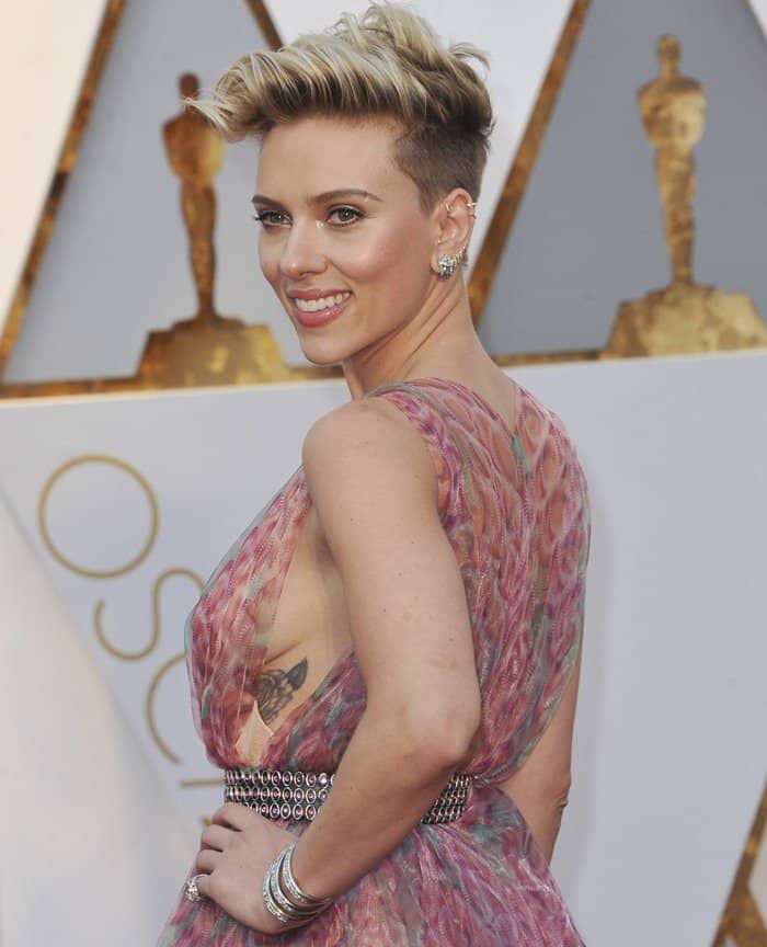 Scarlett Johansson showcased her floral side tattoo in a sheer pink Azzedine Alaïa gown with a studded belt, perfectly blending elegance and edge