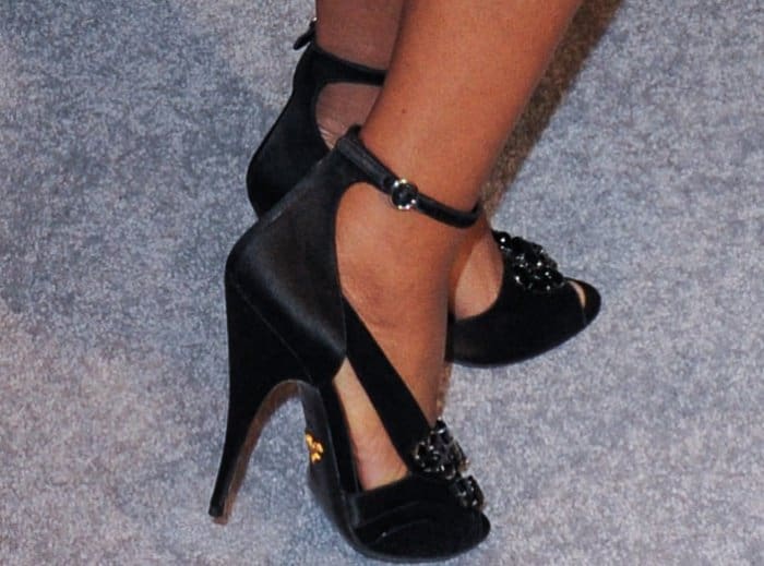 Gabrielle Union completes her look with elegant black satin ankle-strap heels featuring jeweled embellishments at the toes