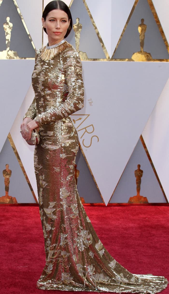 Jessica Biel stuns in a metallic KaufmanFranco gown with intricate silver sequin embellishments, styled with a bold Tiffany & Co. necklace and a sleek updo for a refined red carpet look